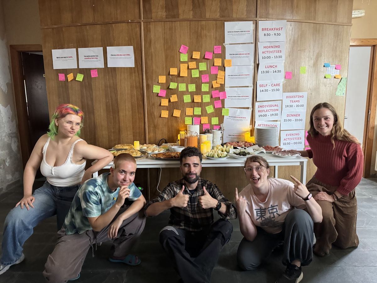 Participantes de Crafted Stories reunidos frente al muro de notas