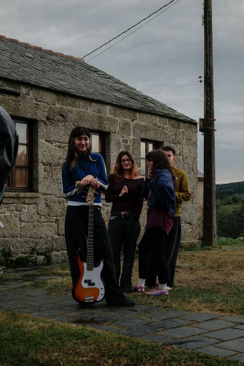 Grupo con un bajo frente a la casa de piedra