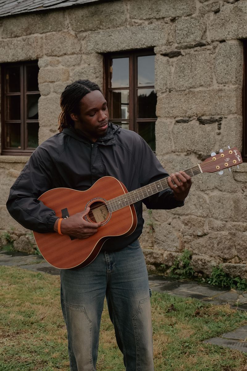Participante tocando la guitarra frente a Das Nest